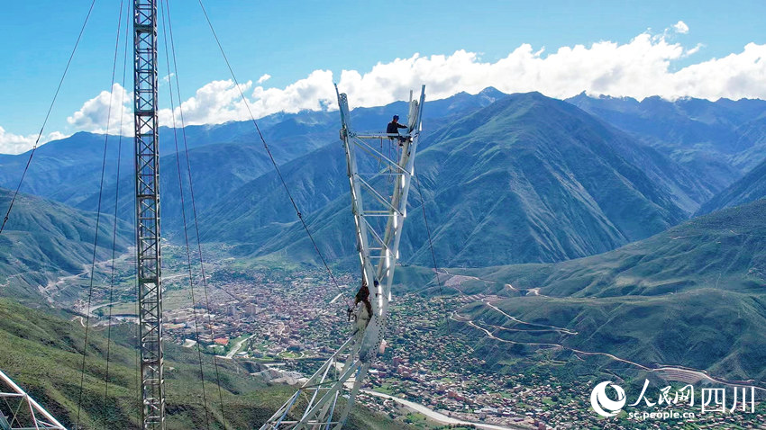 在四川省甘孜州巴塘縣至瀾滄江500千伏線路施工現(xiàn)場，電力工人正在高空進行鐵塔組立作業(yè)。劉洋攝