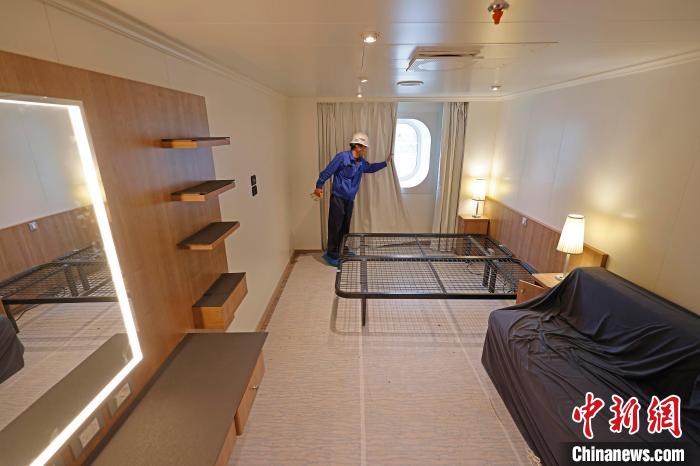 工作人員在船內(nèi)調(diào)試客房窗簾。　殷立勤 攝