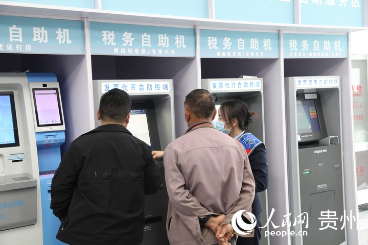 插圖2 都勻市稅務(wù)局工作人員輔導(dǎo)群眾辦稅。人民網(wǎng) 龍章榆攝