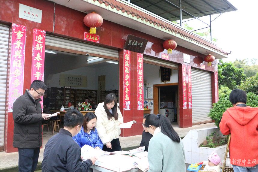 村民在“守一”圖書室外的石桌前圍坐閱讀。李維攝